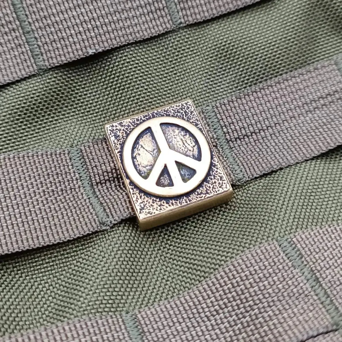 Peace symbol molle clip from bronze